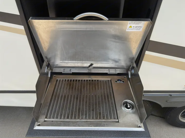 An open, stainless steel outdoor grill built into an RV rental, ready for cooking adventures on the road.. Crossroads RV Sunset Trail Super Lite 2022