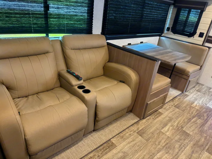 Comfortable RV rental interior featuring plush recliners with cup holders and a dinette area for relaxing.. Crossroads RV Sunset Trail Super Lite 2022