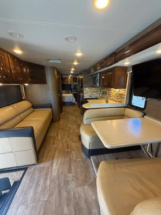 Explore this modern rv rental's interior: comfy sofa, well-equipped kitchen, dining area, and cozy bedroom.. Thor Palazzo 2017