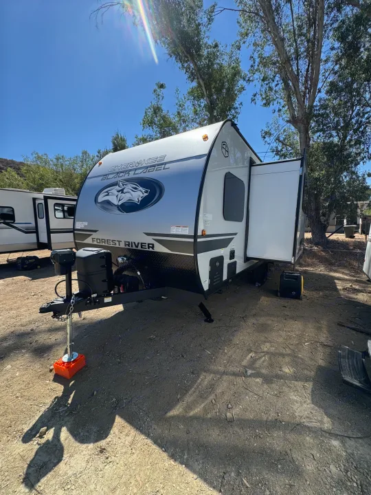 Cherokee Black Label RV rental: a sleek travel trailer parked at a sunny campsite, ready for your next outdoor adventure.. Forest River Cherokee Wolf Pup 2026