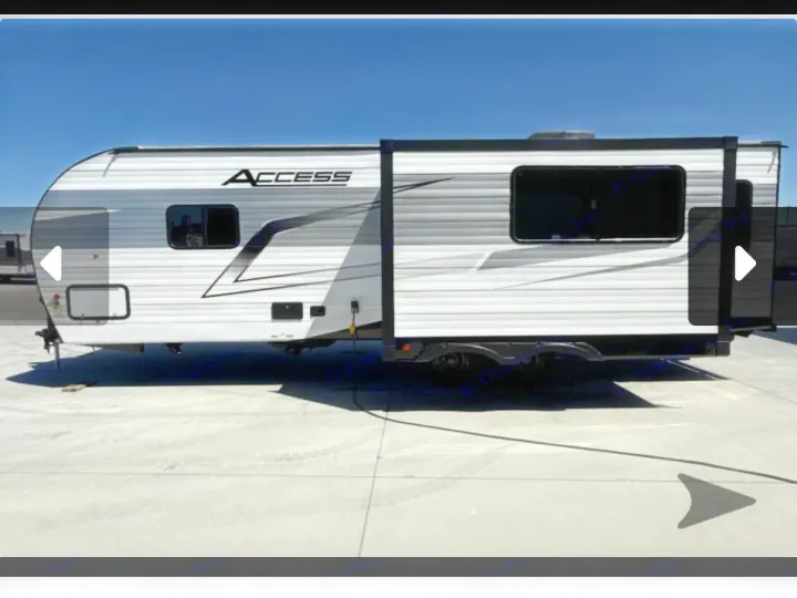 White and grey Access travel trailer RV rental with extended slide-out, parked outdoors. Ready for your camping adventure.. Winnebago Access 2025