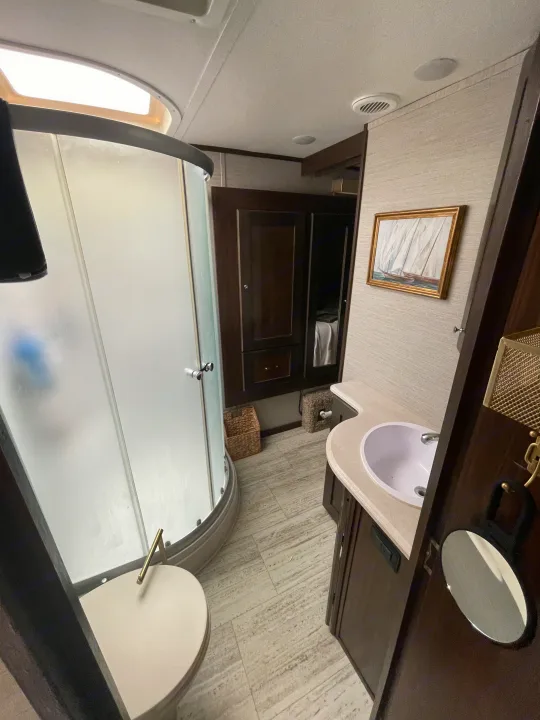 This RV rental bathroom features a compact shower, toilet, and vanity with sink. Enjoy a skylight and modern finishes.. Vanleigh RV Pinecrest 2020