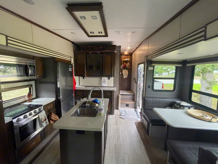 Spacious RV rental kitchen and dinette with modern appliances and light-colored flooring, perfect for travel adventures.. Vanleigh RV Pinecrest 2020