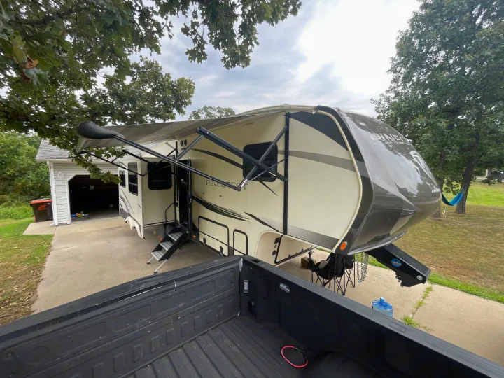 Fifth-wheel rv rental shown with awning extended and steps deployed, parked in a driveway. Ideal for your next outdoor escape.. Vanleigh RV Pinecrest 2020