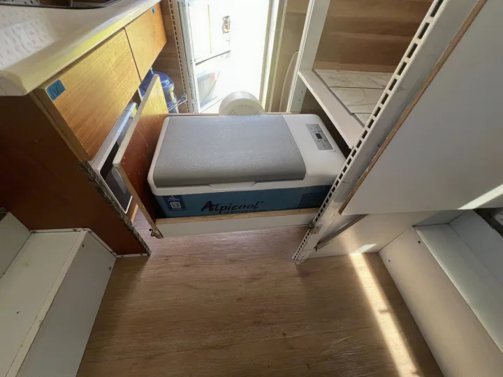 Alpicool portable refrigerator/cooler on a slide-out tray in an RV rental, providing efficient camper van storage.. Ford Ford F150 2019