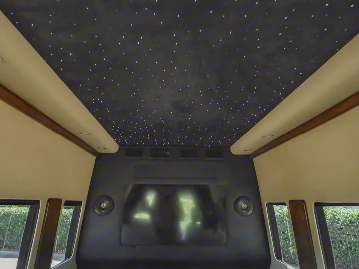 Luxurious RV rental interior features a starlight headliner, large TV, speakers, and plush side panels.. Legends Conversion Sprinter 3500xd 170 Executive Lounger - Ultimate Luxury 2025
