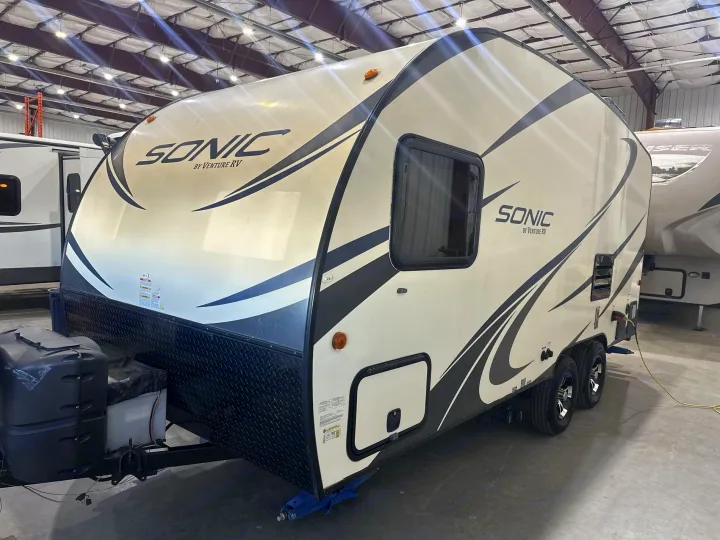 Modern Sonic by Venture RV travel trailer, ideal for an rv rental. Light-colored with black graphics, ready for adventure.. Venture RV Sonic 170 VBH 2017