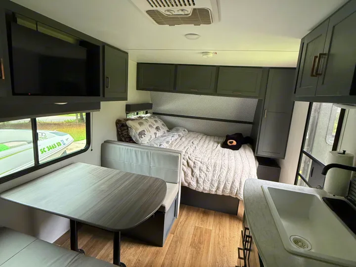 Cozy rv rental interior: bedroom, dinette, and kitchen setup, perfect for compact travel adventures.. Keystone RV Bullet Crossfire 2024