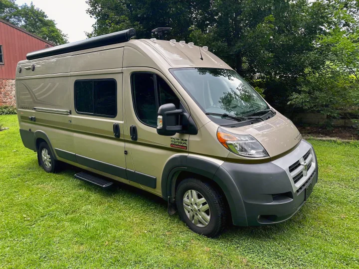Light olive Winnebago Travato camper van, a comfortable rv rental option parked on green grass. Ideal for travel.. Winnebago Travato 2014
