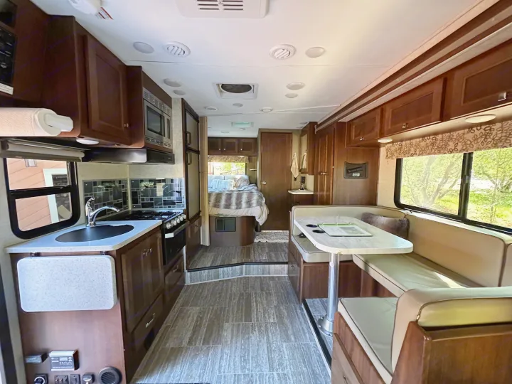 Spacious rv rental interior featuring a full kitchen, comfortable dining dinette, and a cozy bedroom area.. Forest River Forester Classic 2291S 2020