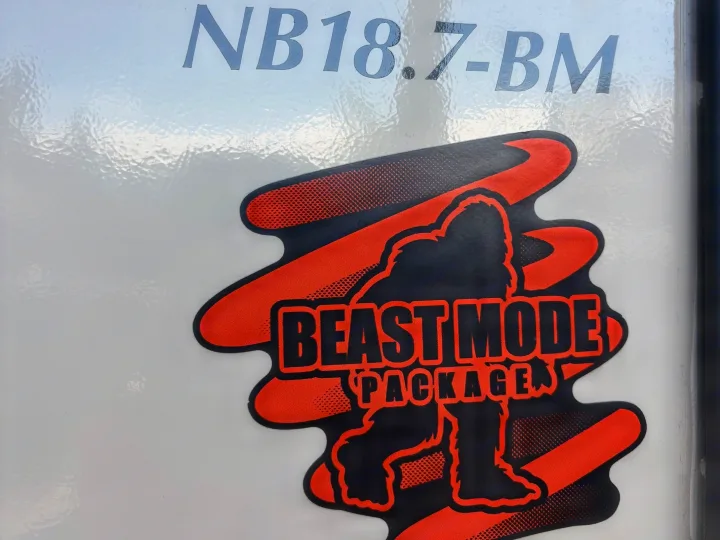 Detail of an RV rental: white exterior, "NB18.7-BM" model text, and a "BEAST MODE PACKAGE" Bigfoot sticker.. No Boundaries 18 2025
