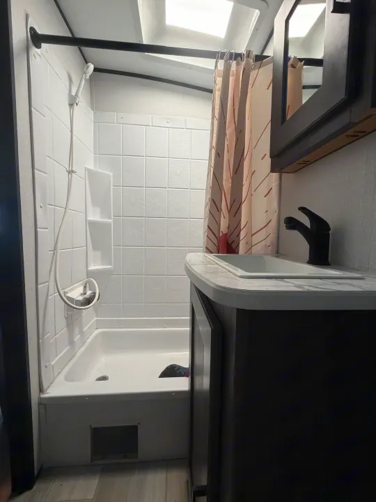 Clean RV rental bathroom featuring a shower, sink, and vanity, ready for your travel accommodations.. Cruiser RV MPG Ultra Lite 2021