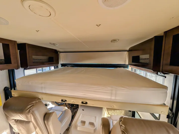 RV rental interior: A lowered overhead bunk bed covers the front cabin, above the driver's and passenger's seats.. Holiday Rambler Admiral 2019