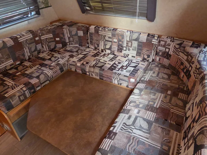 U-shaped RV dinette with patterned cushions & table for your RV rental. Comfort and space for meals on the go.. R-Vision Trail-Lite Trail-Cruiser 2007