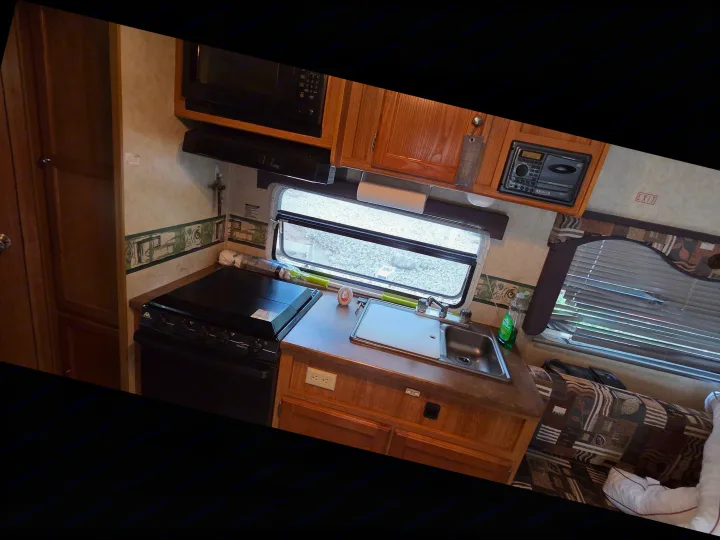 Efficient rv rental kitchen and living space, showing microwave, stove, sink, and EXIT sign near seating.. R-Vision Trail-Lite Trail-Cruiser 2007