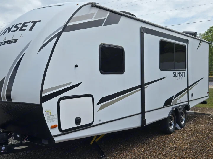 White Sunset Trail travel trailer with black and gray graphics, ready for your next rv rental adventure.. Crossroads RV Sunset Trail Super Lite 2022