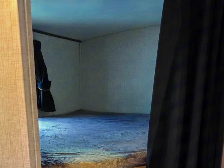 Inside an RV rental, showcasing cozy bunk beds with dark, fuzzy blankets and a privacy curtain to the right.. Crossroads RV Sunset Trail Super Lite 2022