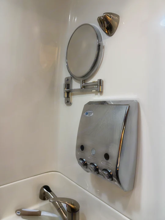 Compact RV rental bathroom featuring an adjustable mirror, a 3-chamber dispenser for toiletries, and a sink with faucet.. Coachmen Galleria 2020