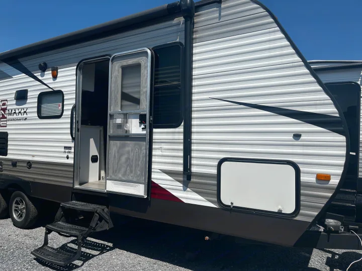 This rv rental travel trailer's exterior features an open door, screen door, steps, and striped siding.. Starcraft AR-One Maxx 2015