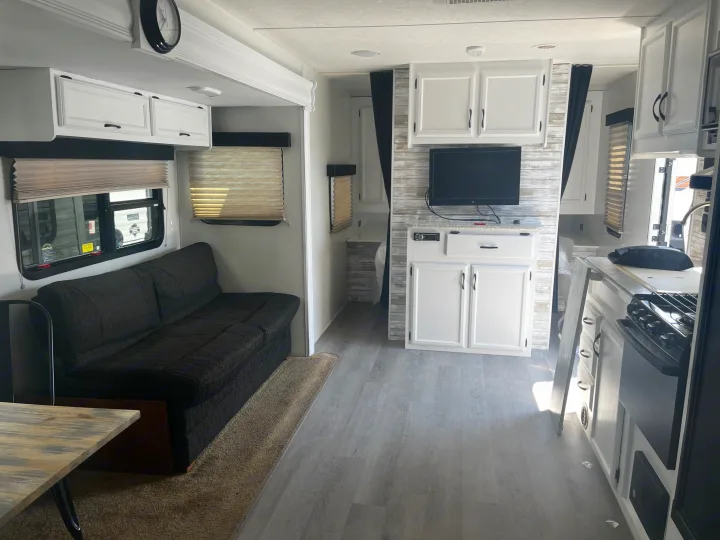 Inside an rv rental: inviting living space with dark sofa, dining table, modern kitchenette, and entertainment center.. Starcraft AR-One Maxx 2015