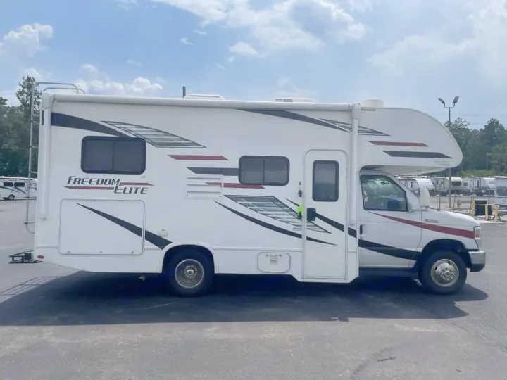 This white Freedom Elite Class C RV rental is parked outdoors, ready for your next adventure.. Thor Freedom Elite 2020