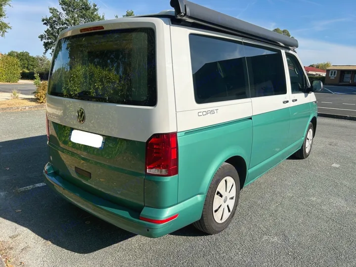 Vibrant two-tone green & white VW California camper van with awning for rv rental, parked on asphalt.. Volkswagen California Coast T6 2020