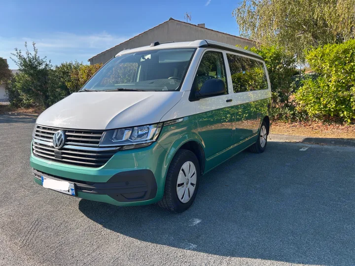 RV rental: A stylish two-tone green and white Volkswagen California camper van parked outdoors on a sunny day.. Volkswagen California Coast T6 2020