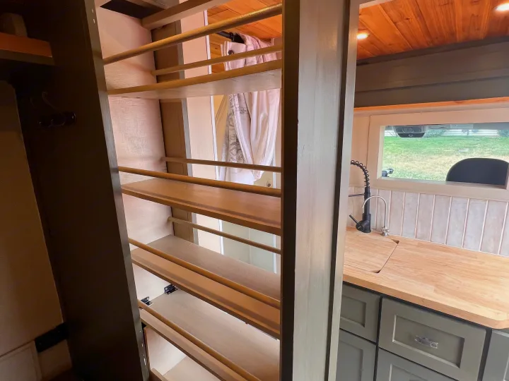 RV rental interior: View of a narrow pull-out pantry with wood shelves and a compact kitchen with wooden countertop and gray cabinets.. Dodge Ram Promaster 2500 2020