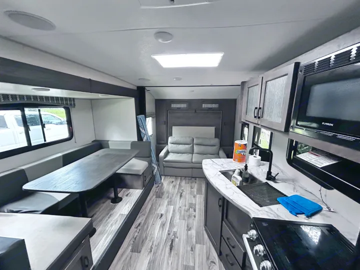Spacious RV rental interior with a modern kitchen, comfortable dinette seating, and a sofa bed. Perfect for your travels.. Sonic Sonic Trailer 2022