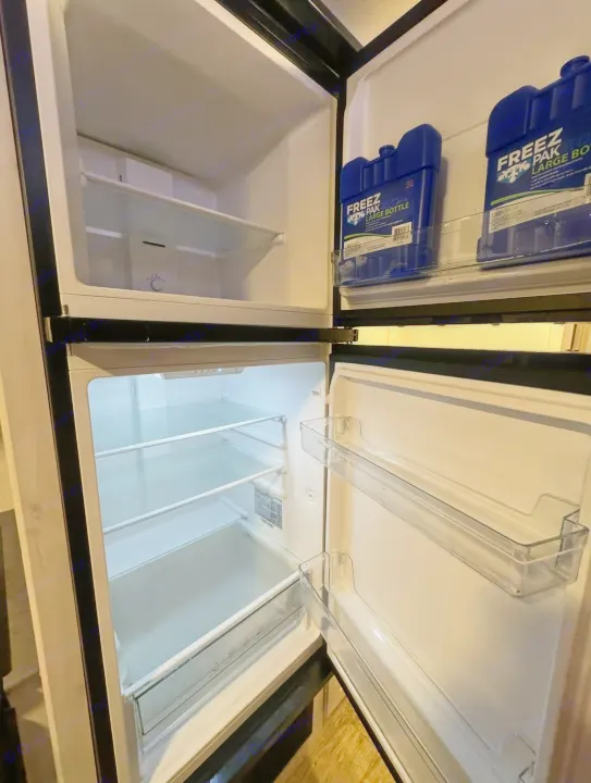 Empty RV rental refrigerator and freezer with blue ice packs on door. Ready for your food!. Forest River Cherokee 2022