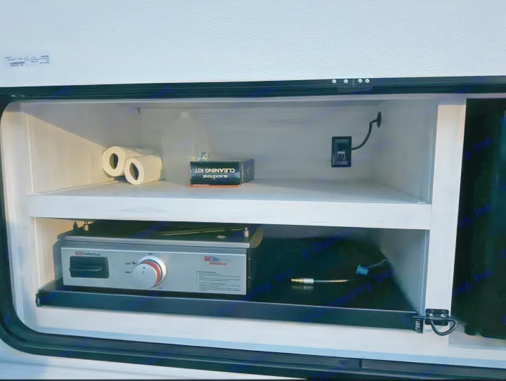 This RV rental's outdoor kitchen setup includes a griddle, Blackstone cleaning kit, toilet paper, and an outlet for convenience.. Forest River Cherokee 2022