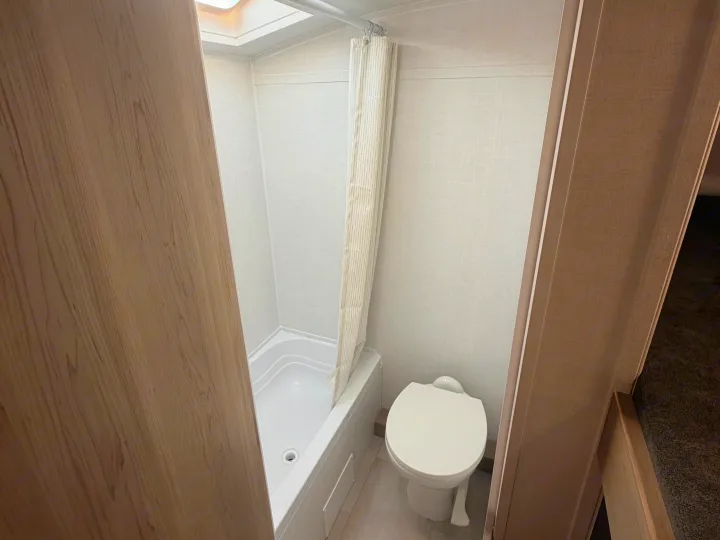 Compact RV rental bathroom: shower/tub, toilet, light-colored walls, and wood-look trim.. Forest River Rockwood Geo Pro 17LE 2026