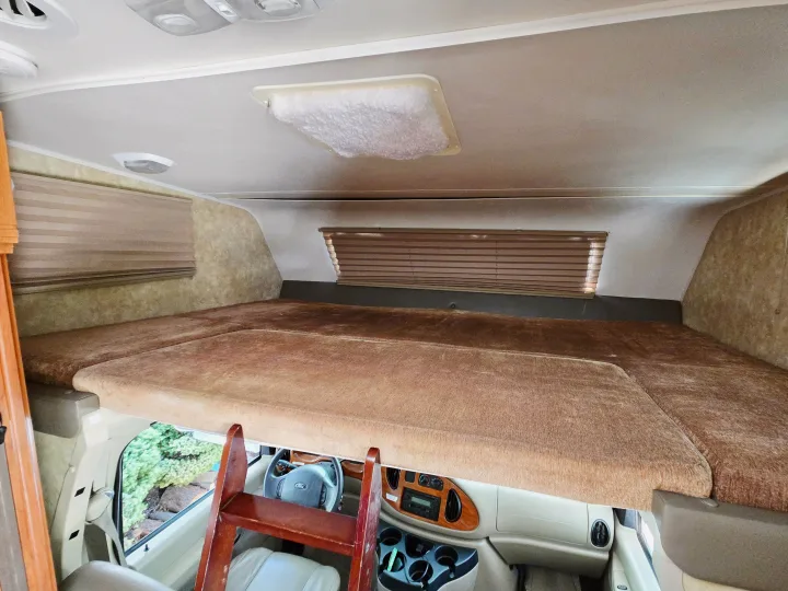 Spacious cab-over sleeping bunk in this RV rental, with a ladder & driver's area below.. Coachmen Freedom Express 2008