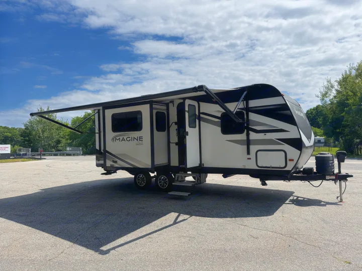 White & black travel trailer, awning extended, for your next rv rental adventure. Ready for camping!. Grand Design Imagine XLS 2024