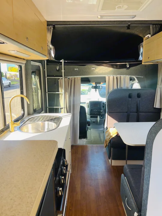 Cozy rv rental interior with a bright kitchen, dining area, and an overhead bed for comfortable travel.. Mercedes-Benz Other 2018