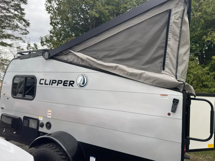 Grey pop-up RV rental with 'Clipper' branding and partially extended canvas roof for travel adventures.. Forest River Coachmen Clipper 2023