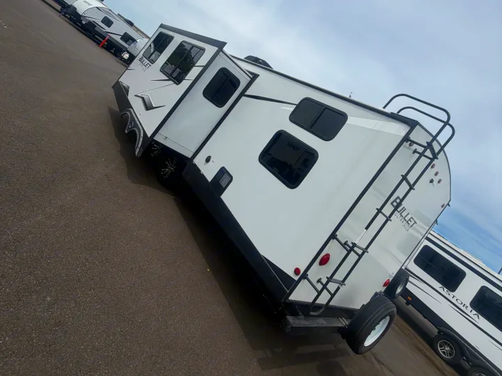 Two white travel trailers (RVs), a Bullet Ultra-Lite in front, parked on asphalt for your next rv rental.. Keystone RV Bullet Ultra Lite 2022