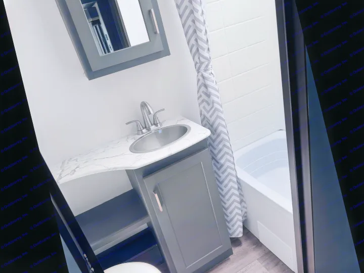 Compact RV rental bathroom with a sink, marble-look vanity, dark grey cabinets, and a shower/tub with a chevron curtain.. Keystone RV Bullet Ultra Lite 2022