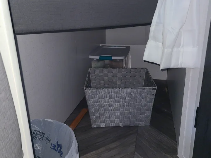 RV rental under-bed storage: a woven basket, plastic bin, and trash bag organized in a compact interior space.. Forest River Salem FSX 2019