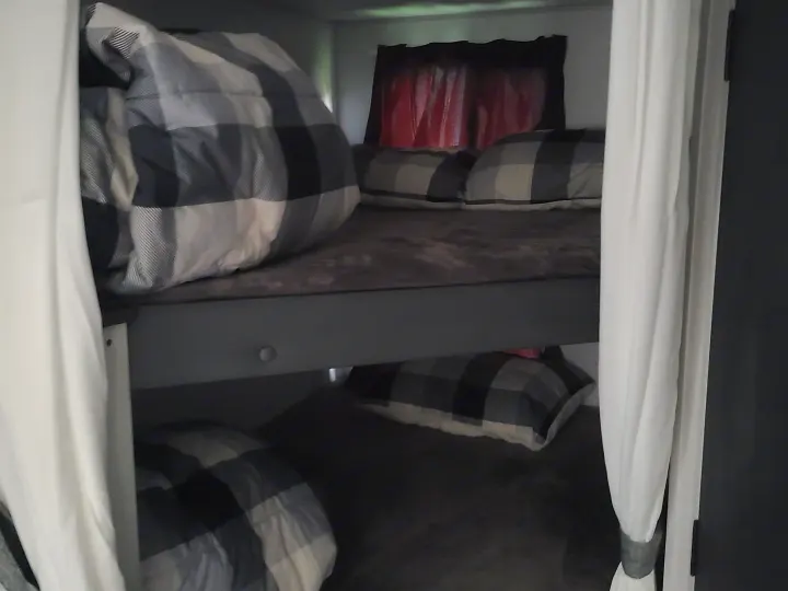 Cozy RV rental bunk beds with buffalo plaid bedding and privacy curtains, perfect for a family adventure.. Forest River Salem FSX 2019