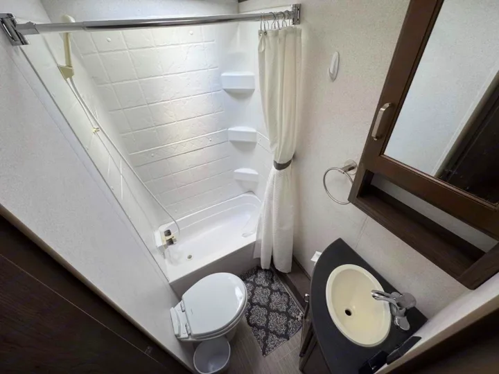 RV rental bathroom: compact design with shower/tub, toilet, and sink. Clean and functional interior.. Keystone RV Passport Grand Touring 2019