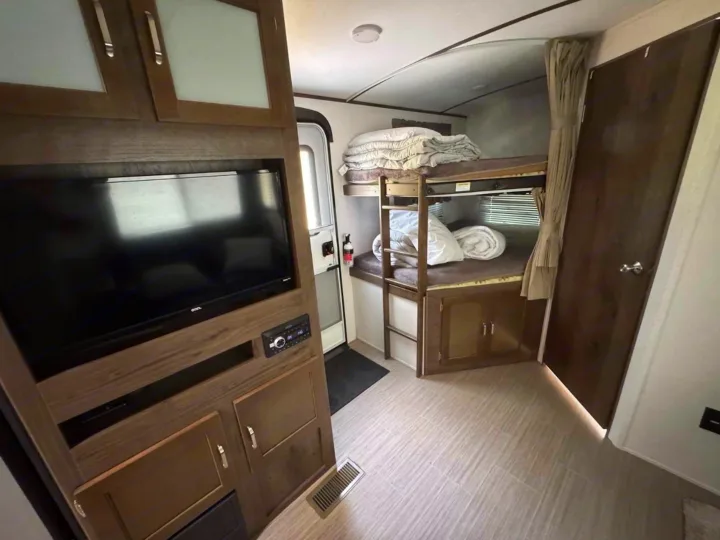 Inside this cozy RV rental, discover bunk beds for extra sleeping, an entertainment unit with a TV, and a full-size entrance door.. Keystone RV Passport Grand Touring 2019