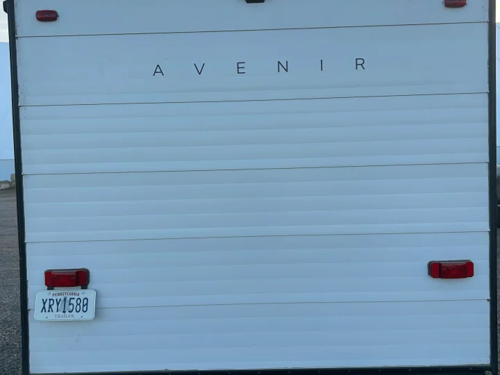 Rear of white Avenir RV rental trailer, featuring horizontal siding, and PA license plate XRY1588, labeled 'TRAILER'.. Cruiser RV A-17BH Avenir 2024