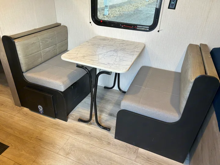 RV rental dinette with cozy benches, marble-look table, and window. Perfect for meals or work.. Cruiser RV A-17BH Avenir 2024