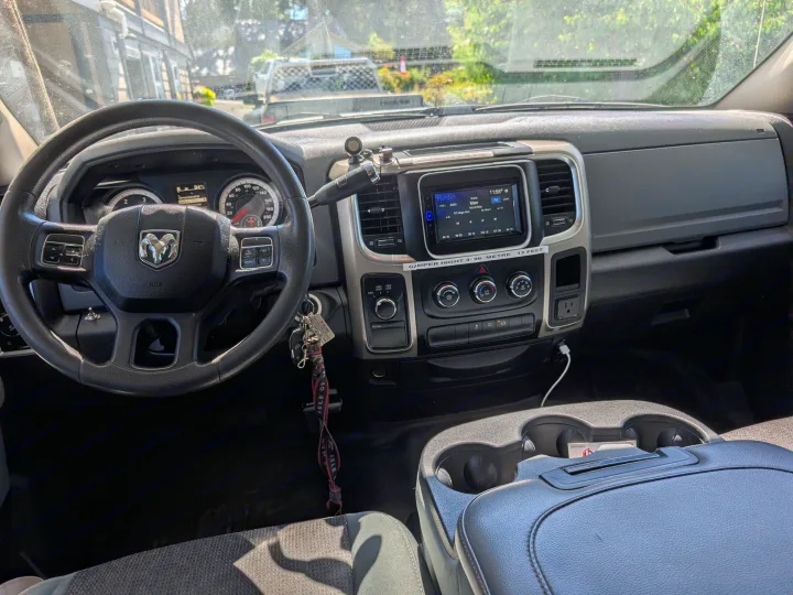 View from the driver's seat of an RV rental truck. Dashboard, steering wheel, and radio are visible, along with a camper height warning.. Dodge Dodge 1 Ton Pu 2014