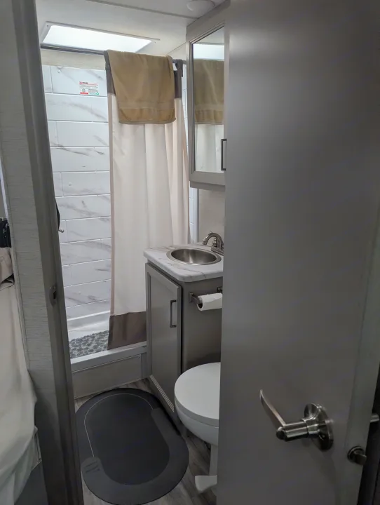 RV rental bathroom: Tiled shower, vanity with a round sink, and toilet are visible in this compact, modern space.. Thor Quantum SE 2025