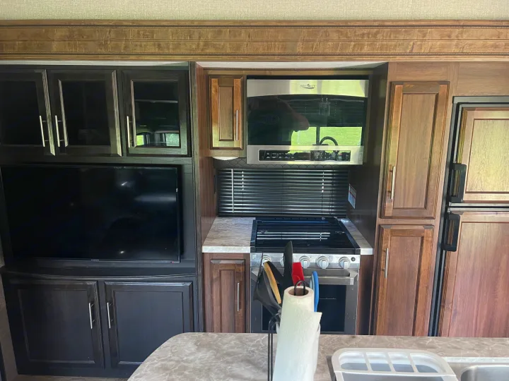 Comfortable RV rental kitchen & living space: microwave, stove, fridge, TV, and ample cabinet storage.. Jayco Eagle HT 2020