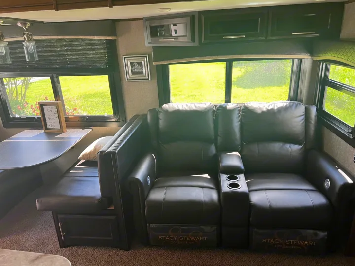 RV rental comfort: dark leather recliners with cup holders, a dining booth, and bright windows for scenic views.. Jayco Eagle HT 2020