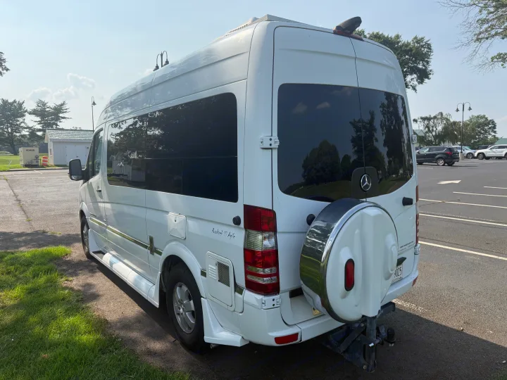 White Roadtrek SS Agile rv rental campervan (Mercedes-Benz Sprinter) parked outdoors, seen from the rear-side.. Roadtrek Roadtrek Class B 2014