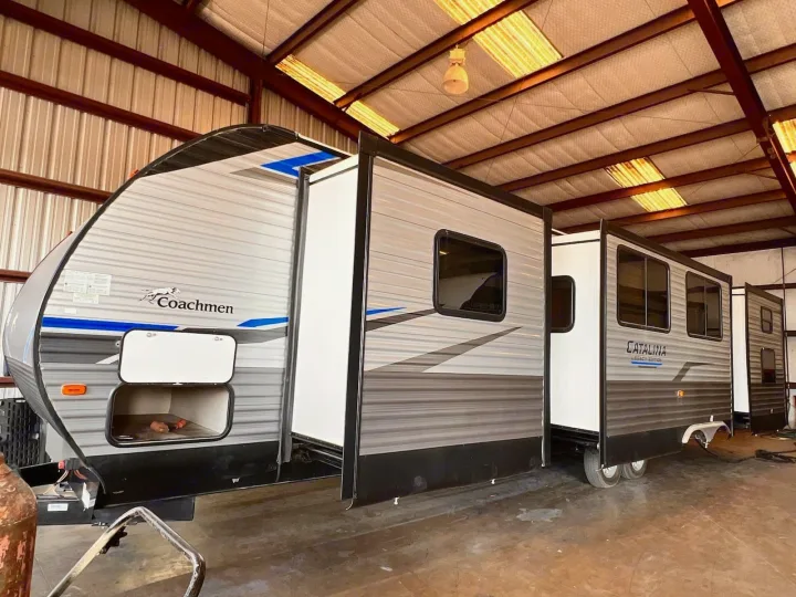 This Coachmen Catalina RV rental, a travel trailer with extended slide-outs, is parked indoors, ready for adventure.. Coachmen Catalina 2022